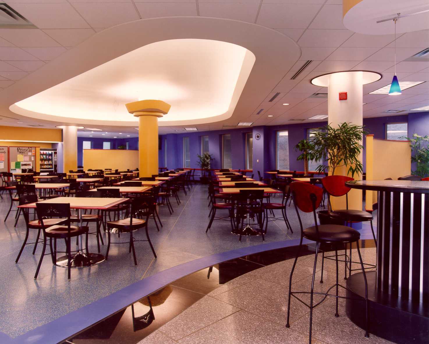 A colorful cafeteria with a plaster compound radius bulkhead, indirect lighting, granite accent flooring